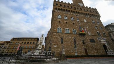 Touristin klettert auf Neptunbrunnen in Florenz