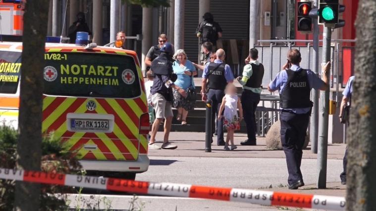 Einige Geiseln verlassen, von Polizisten begleitet, das Kino in Viernheim.