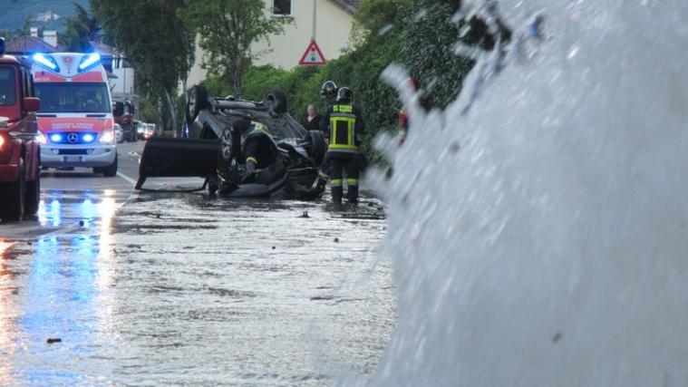 Aus dem angefahrenen Hydranten traten Wassermassen aus, der Pkw überschlug sich und blieb auf dem Dach liegen. - Foto: Berufsfeuerwehr Bozen