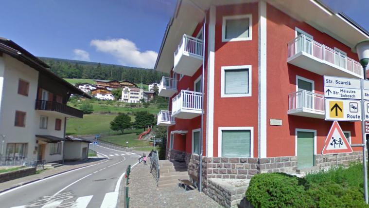 Das Haus, in dem die Flüchtlinge in St. Ulrich unterkommen sollen (r.), liegt unweit der Schule (hinten).