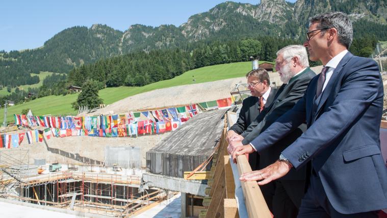 Europaregion im Wandel: Anlässlich des Tiroltages besichtigen Günther Platter, Franz Fischler und Arno Kompatscher den Erweiterungsbau des Congress Centrums Alpbach. Die Fahnen repräsentieren die Teilneher des Forums aus 86 Nationen.