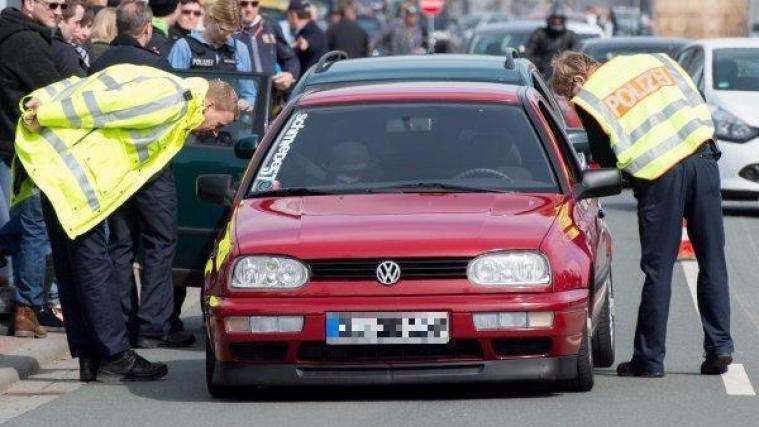 Polizisten kontrollieren in Limburg an der Lahn (Hessen) ein getuntes Auto. Obwohl der Veranstalter den "Carfreitag" 2015 offiziell abgesagt hatte, kamen hunderte Zuschauer und Fans der Tuning-Szene aus ganz Deutschland zu dem Treffen in einem Gewerbegebiet.