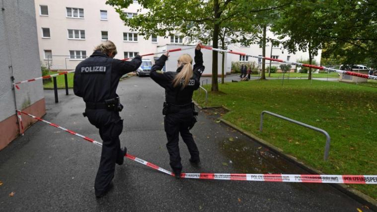 Polizeibeamte betreten das abgesperrte Gelände rund um das Haus in Chemnitz, in dem hochexplosiver Sprengstoff gefunden wurde.