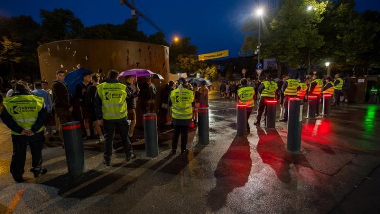 Wiesn-Besucher warten bei Morgengrauen vor dem Haupteingang zum Oktoberfest auf der Theresienwiese in München.