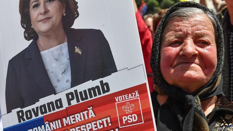 Eine Frau mit einem Wahlplakat von Rovana Plumb Foto: APA/AFP
