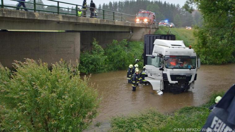 Zugfahrzeug und Anhänger kamen in der Flussmitte zum Stehen. - Foto: APA (BFKDO Waidhofen/Thaya )