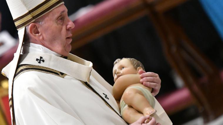 Papst Franziskus mit einer Schnitzerei des Jesukindes.