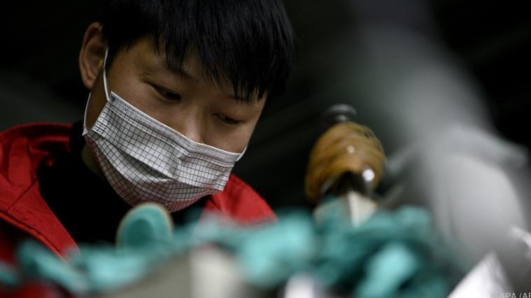 Eine Fabriksarbeiterin in China mit einer Gesichtsmaske.