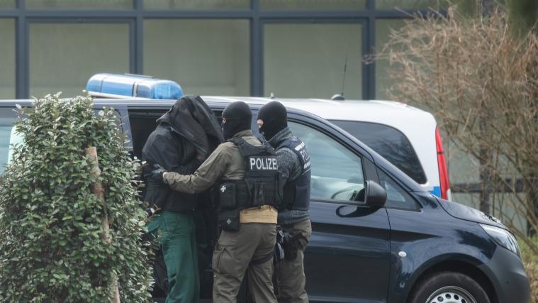 Eine Person wird von Polizisten in Karlsruhe mit zum Bundesgerichtshof gebracht.