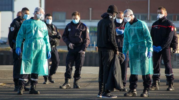 Migranten im Gespräch mit Polizisten im Hafen von Calais.