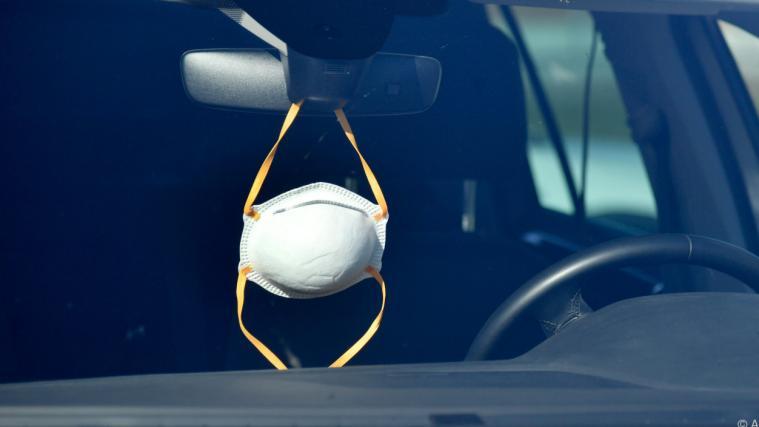 Die Maske hängt inzwischen oft am Rückspiegel im Auto.