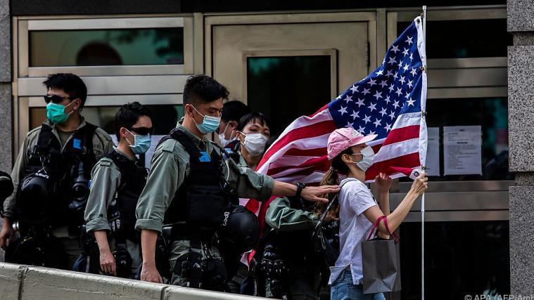 Hongkongs Polizei vertreibt Frau mit US-Flagge.