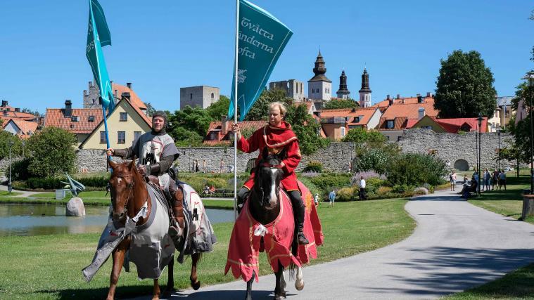 Verkleidet und auf Pferden reitend erinnern die Männer an die Abstandsregeln.
