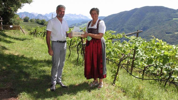 Landesbäuerin Antonia Egger dankt Landesrat Arnold Schuler mit bäuerlichen Produkten.