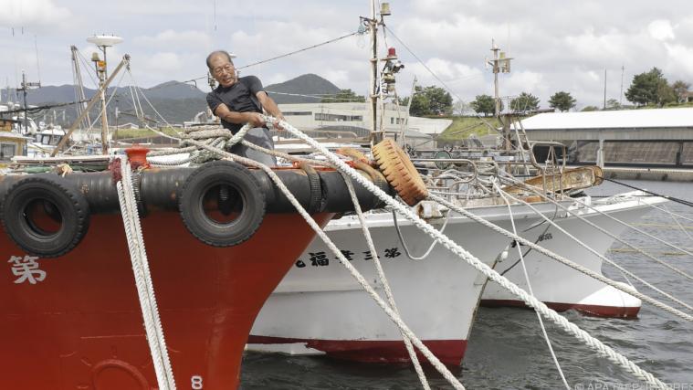 Japanische Fischer vertäuen ihre Boote vor dem Taifun.
