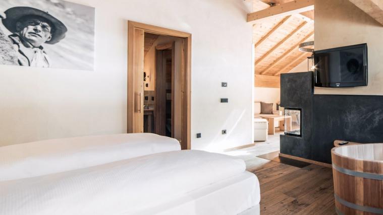 Genießen Sie eine wohlverdiente Auszeit in der Curasoa Suite mit handgefertigter Holzbadewanne, Infrarotkabine und Kamin.
