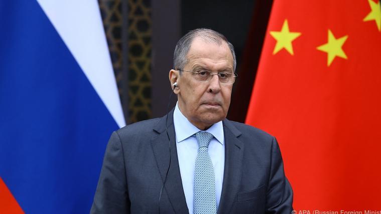 Der russische Außenminister Alexej Lawrow streckt seine Hand Richtung China aus.