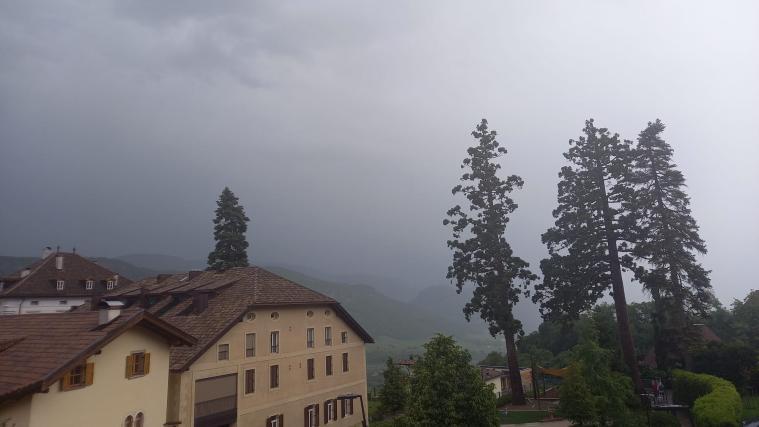 Der Blick von Kaltern Dorf in Richtung Kalterer See: Dunkle Wolken und Regen prägen das Wetter am heutigen Donnerstagnachmittag.