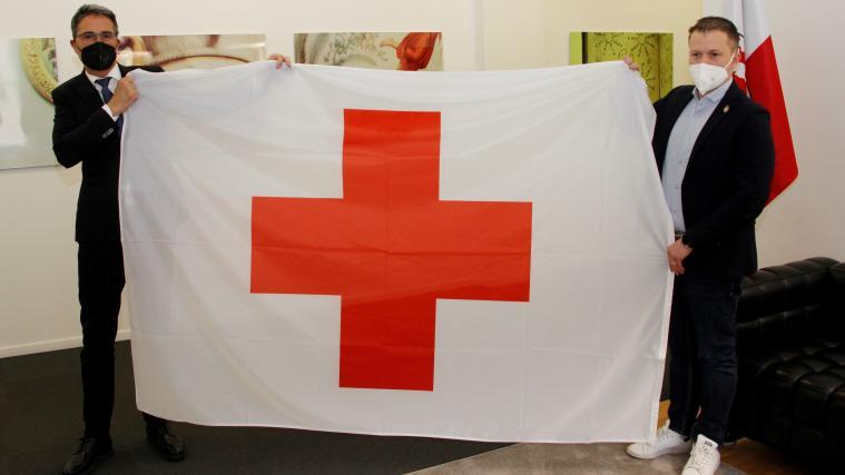 LH Arno Kompatscher (r.) und der Präsident des IRK Südtirol Manuel Pallua: Flagge als Zeichen für das gemeinsame Ziel, die Solidarität und das friedliche Zusammenleben zu stärken.