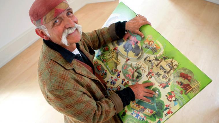Ali Mitgutsch hält im Bilderbuchmuseum eines seiner Kinderbücher in Händen.
