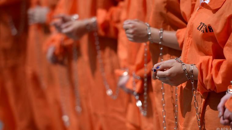 Ketten und orange Uniformen gelten als Symbol für Guantanamo.